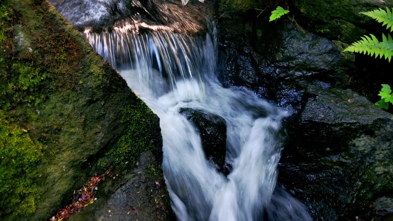 冰冷的水流下岩石和石块视频素材