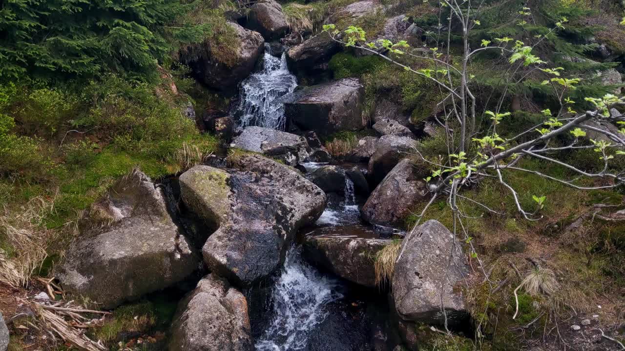 一条小山涧从岩石上流下来。胶片颗粒视频素材