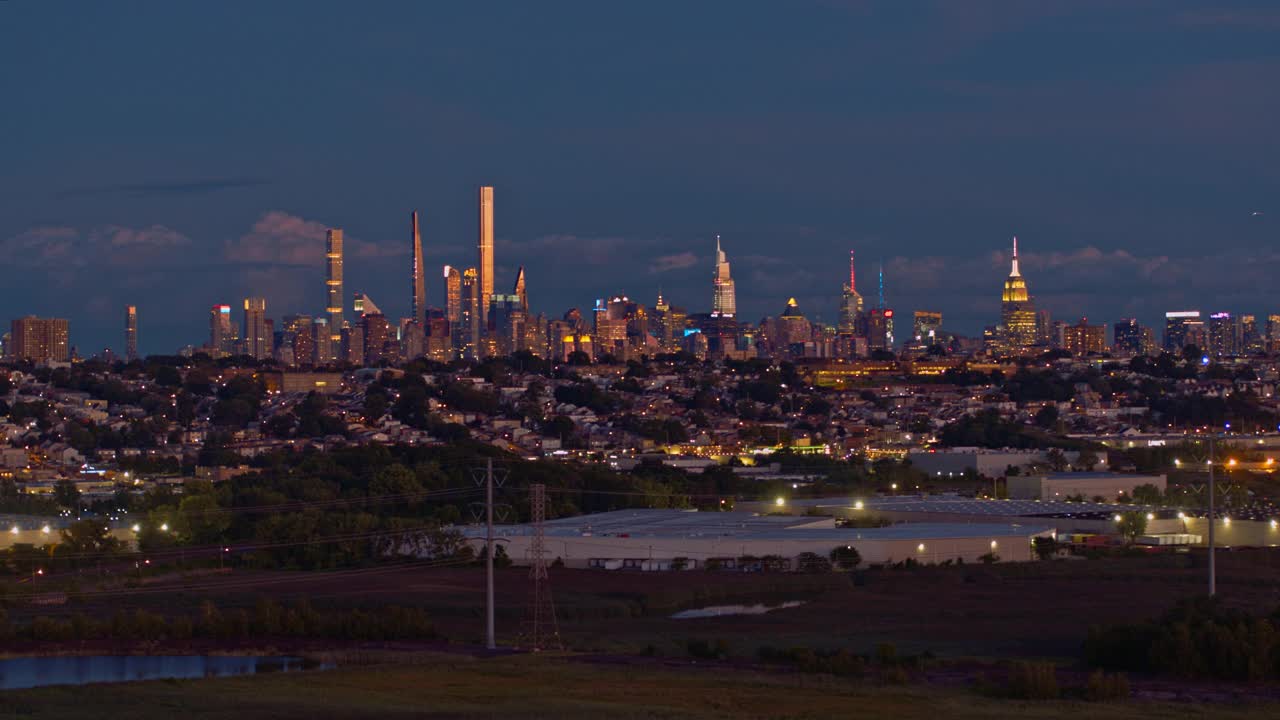 曼哈顿，纽约市，纽约州和泽西城在新泽西工业区的夜景。静态摄像机的航拍视频。视频素材