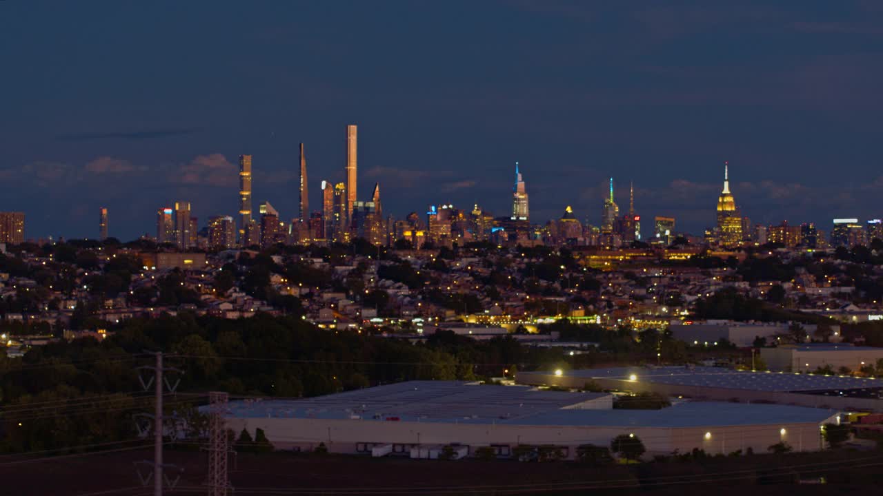 曼哈顿，纽约市，纽约州和泽西城在新泽西工业区的夜景。航拍视频与平移摄像机运动。视频素材