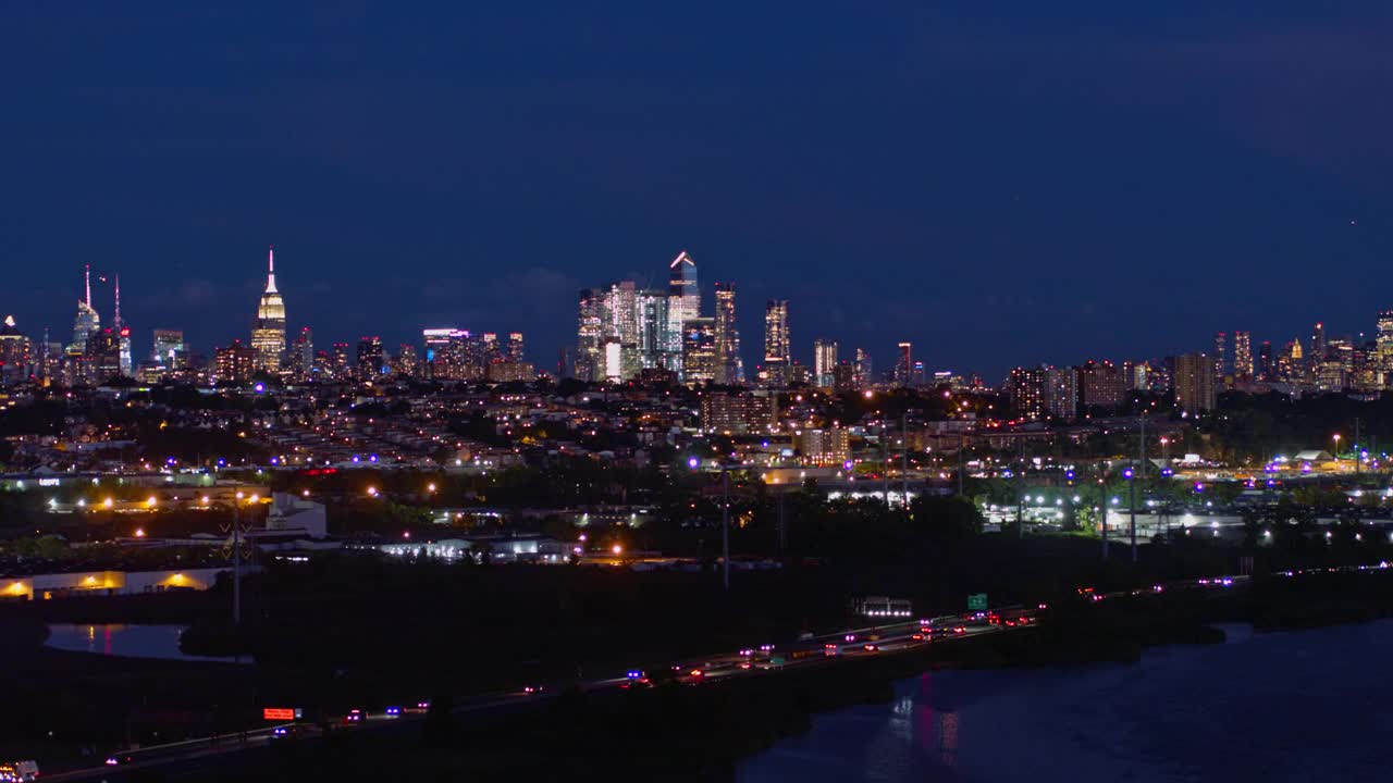 曼哈顿，纽约市，纽约州和泽西城在新泽西工业区的夜景。航拍视频与平移摄像机运动。视频素材