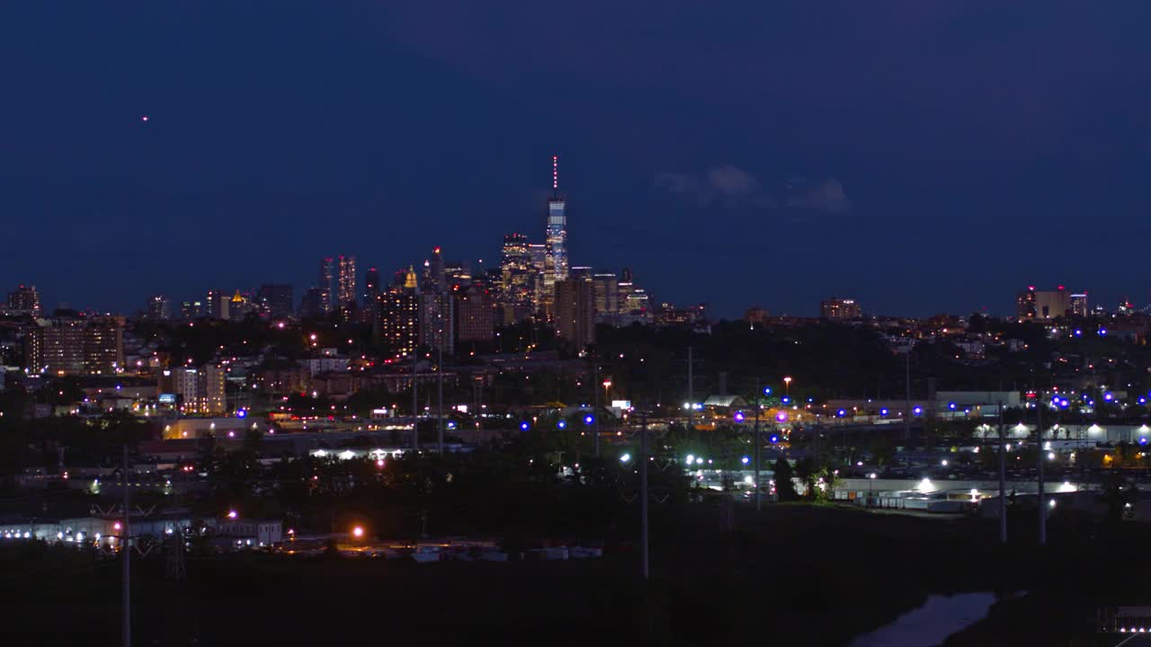 曼哈顿，纽约市，纽约州和泽西城在新泽西工业区的夜景。航拍视频与平移摄像机运动。视频素材