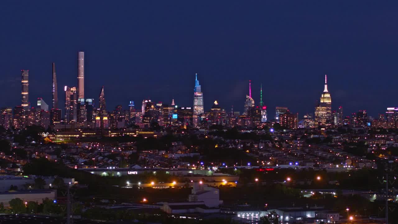 曼哈顿，纽约市，纽约州和泽西城在新泽西工业区的夜景。航拍视频与平移摄像机运动。视频素材