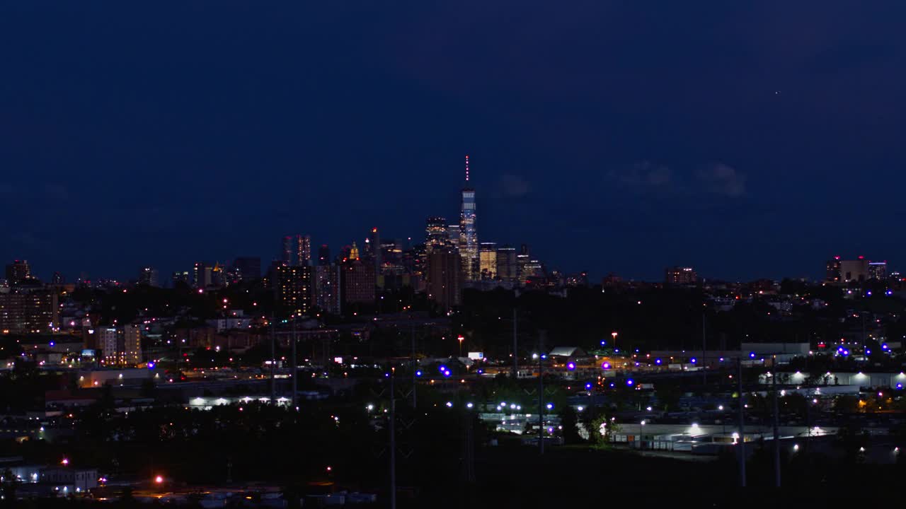 曼哈顿，纽约市，纽约州和泽西城在新泽西工业区的夜景。航拍视频与平移摄像机运动。视频素材