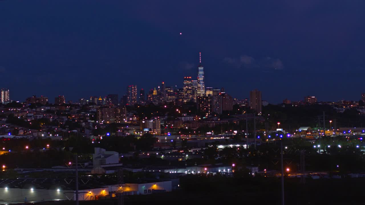 曼哈顿，纽约市，纽约州和泽西城在新泽西工业区的夜景。航拍视频与平移摄像机运动。视频素材