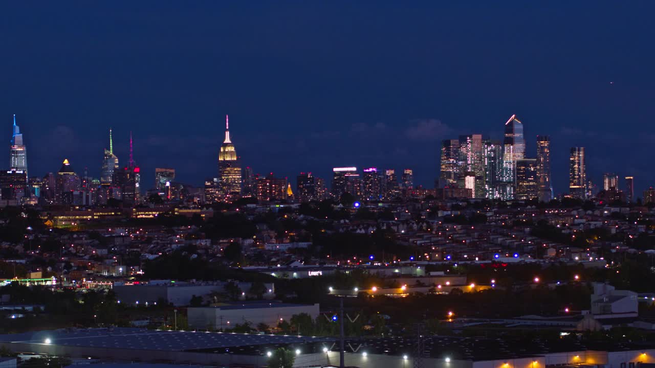 曼哈顿，纽约市，纽约州和泽西城在新泽西工业区的夜景。航拍视频与平移摄像机运动。视频素材