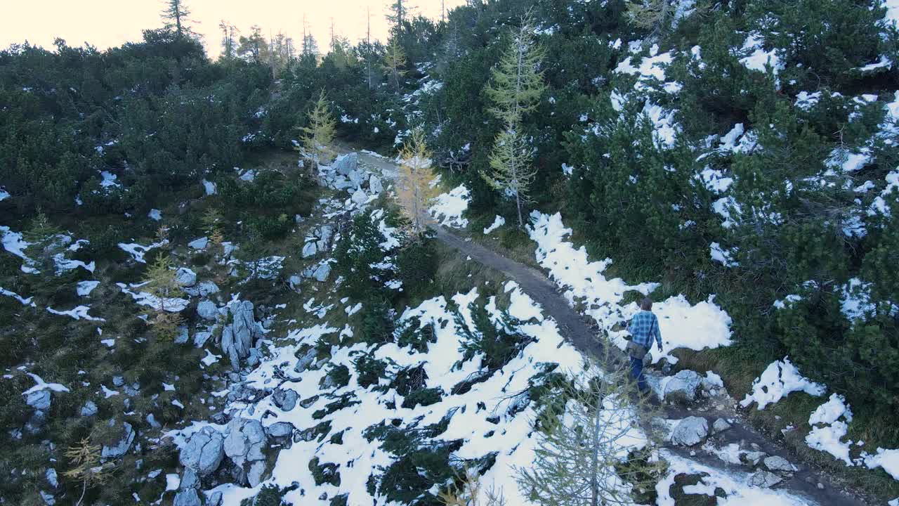 无人机对成年男子在雪山徒步的观点视频素材