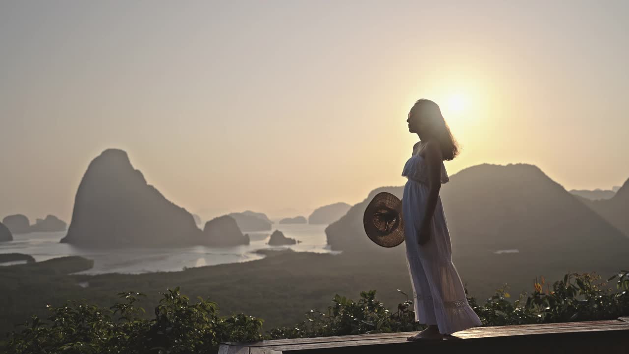 一名女游客站在山顶，欣赏令人叹为观止的日落美景视频素材