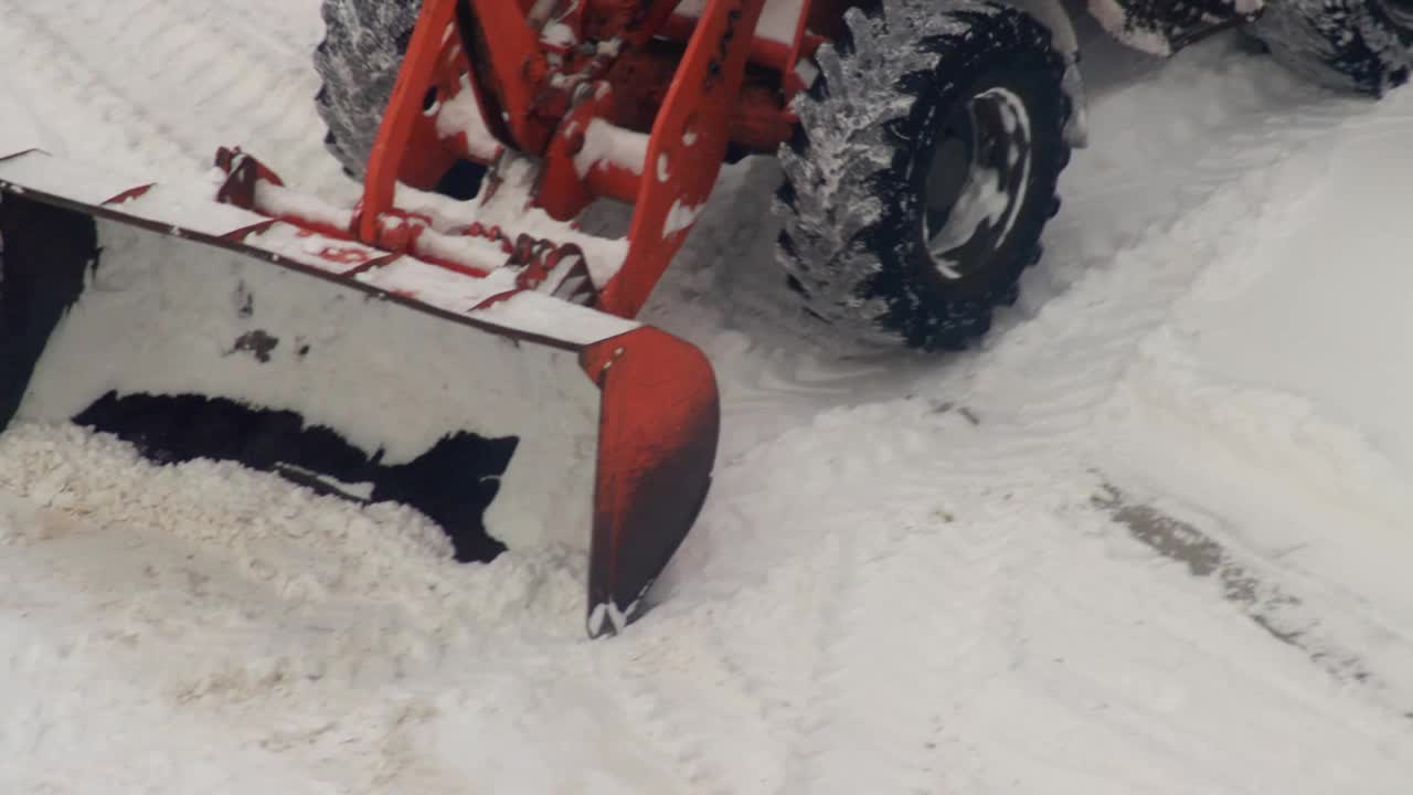 黄色铲斗的装载机在冬天清理道路和除雪。除雪设备视频素材