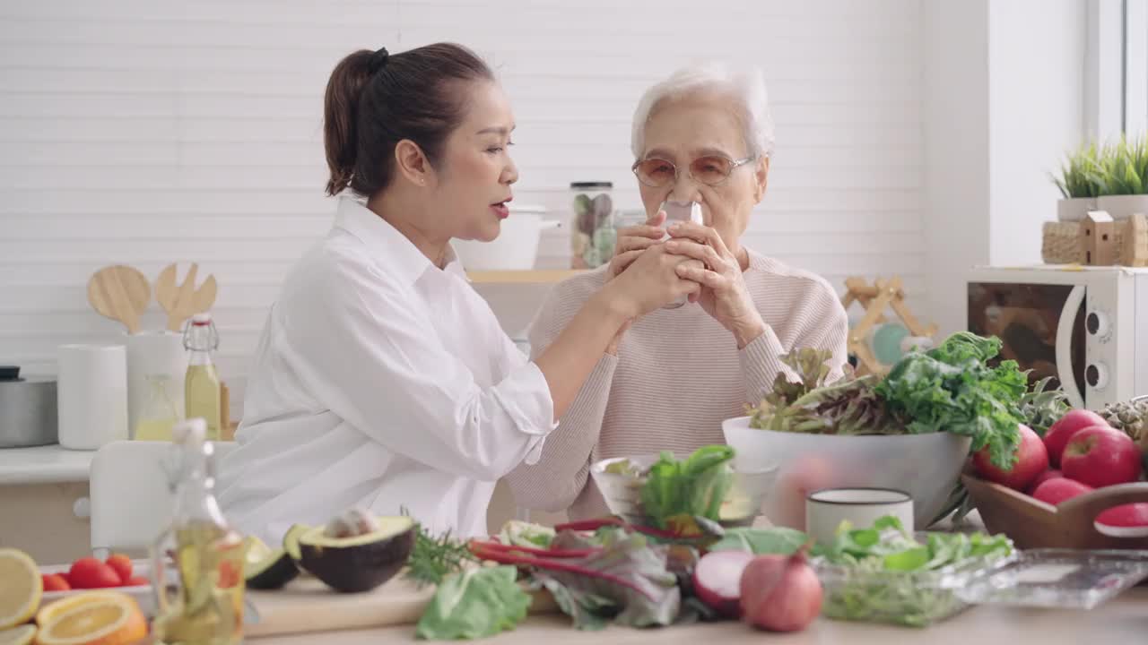 与女儿一起在厨房准备早餐、蔬菜、水果，喝亚洲妈妈的牛奶，享受周末的活动视频下载