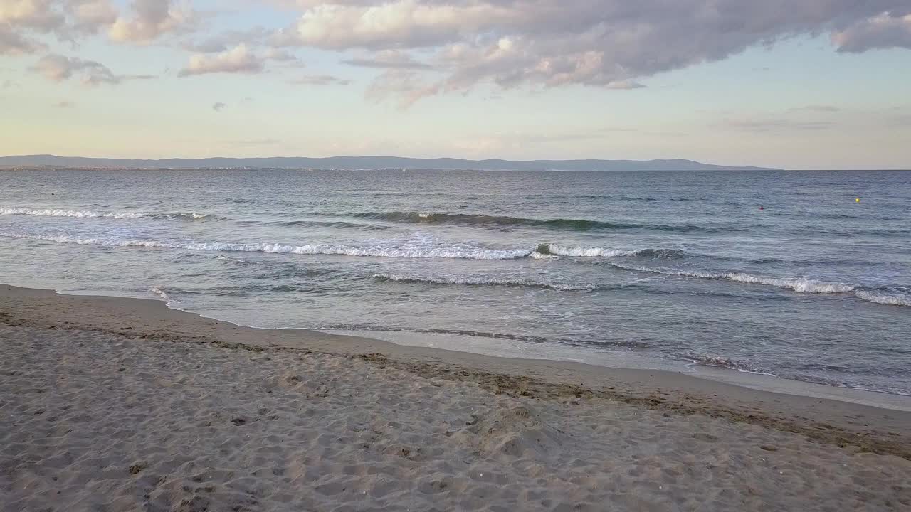 鸟瞰图的海面与蓝色的海浪在日落的天空下视频素材