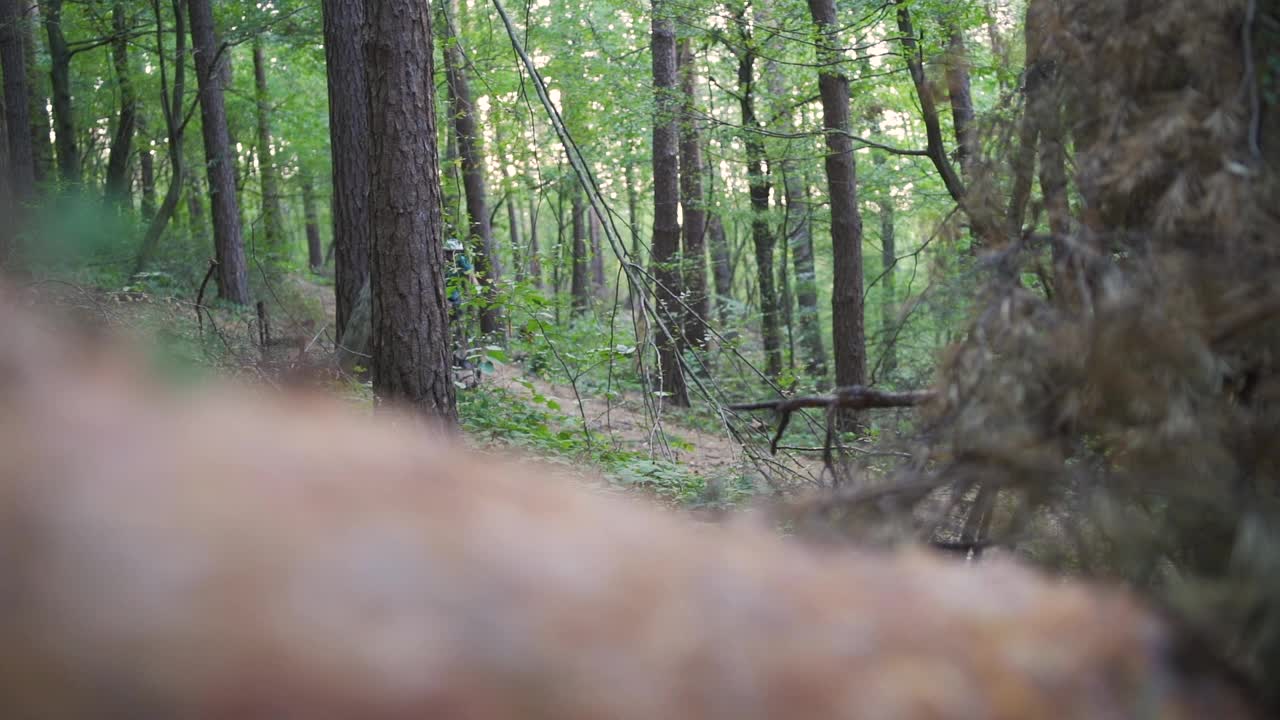 年轻的山地自行车手在森林里的一条小路上爬行视频素材