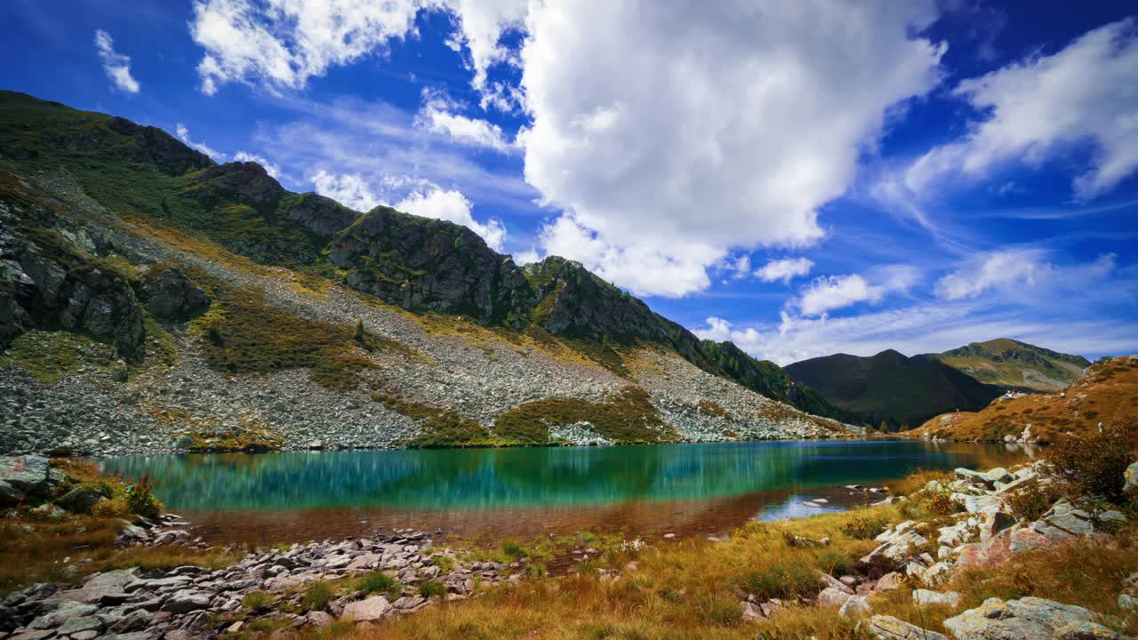 时光流逝-高山的神奇绿色湖泊。
蔚蓝的天空和蓬松的云朵与太阳交替出现。
意大利阿尔卑斯山。视频素材