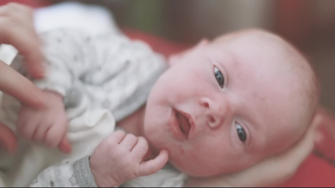 母亲的手玩弄着新生婴儿的小手视频素材