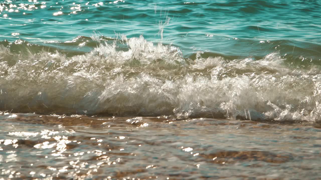 绿色的海浪在岸边飞溅，闪闪发光视频下载