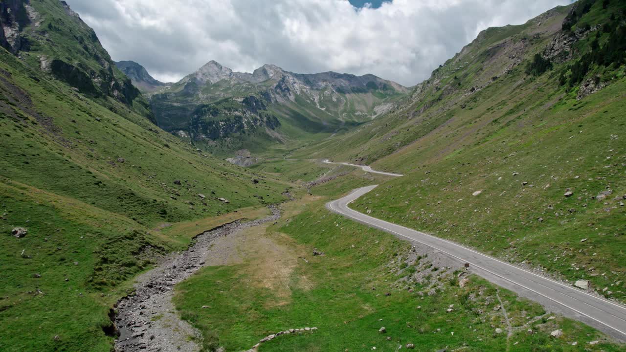 在高山山谷的山坡上的汽车道路。穿越山脉的度假旅行视频素材