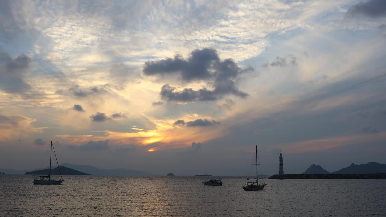 在夕阳海景。海岸上的灯塔。海边小镇Turgutreis和壮观的日落视频素材