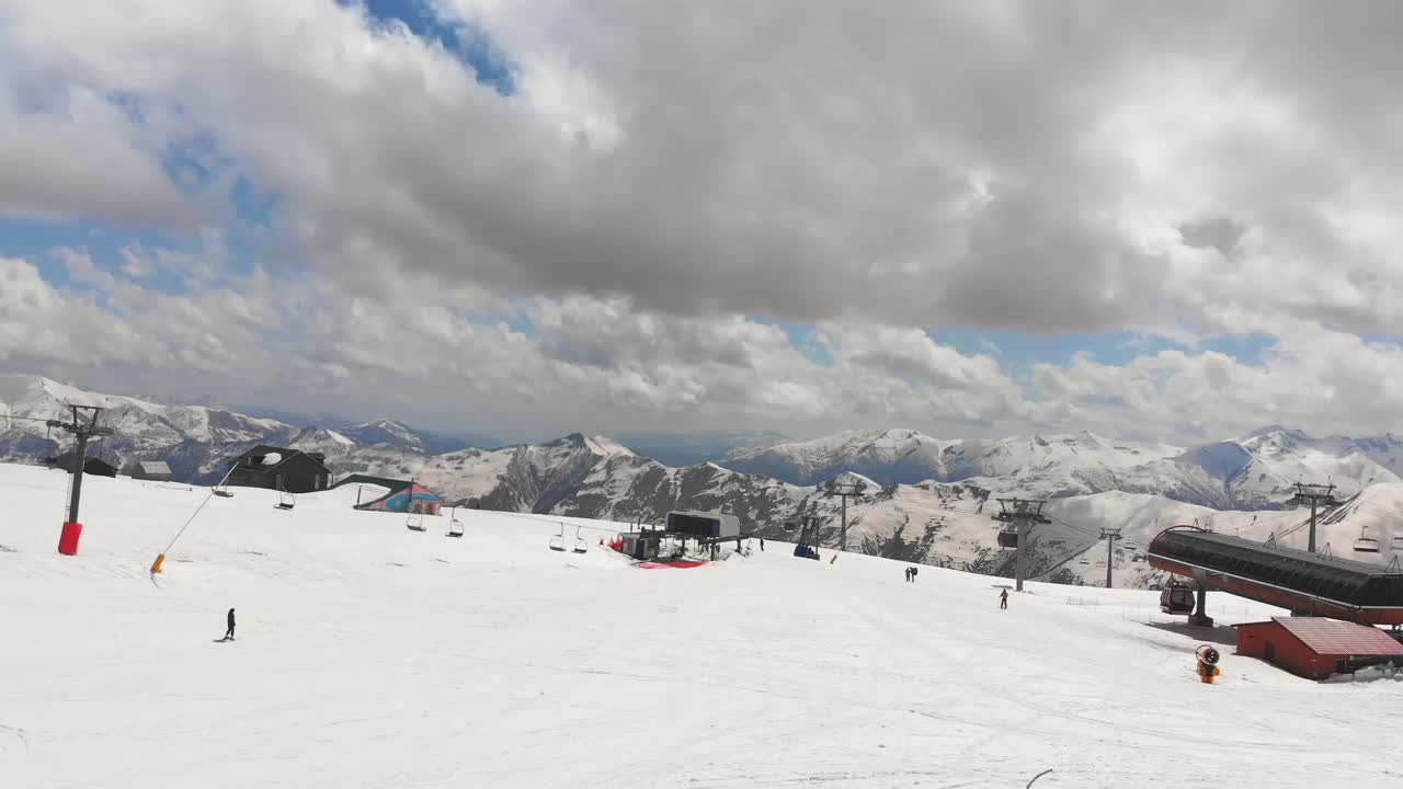 追踪鸟瞰图初学滑雪的女性滑雪者在龟道里滑雪场的蓝色斜坡上滑下山。旅游度假胜地。视频素材