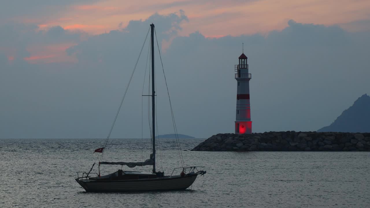 在夕阳海景。海岸上的灯塔。海边小镇Turgutreis和壮观的日落视频素材