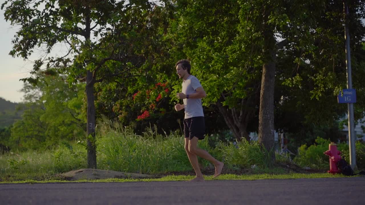 一个年轻人赤脚跑步的慢镜头。赤脚跑步的概念视频素材