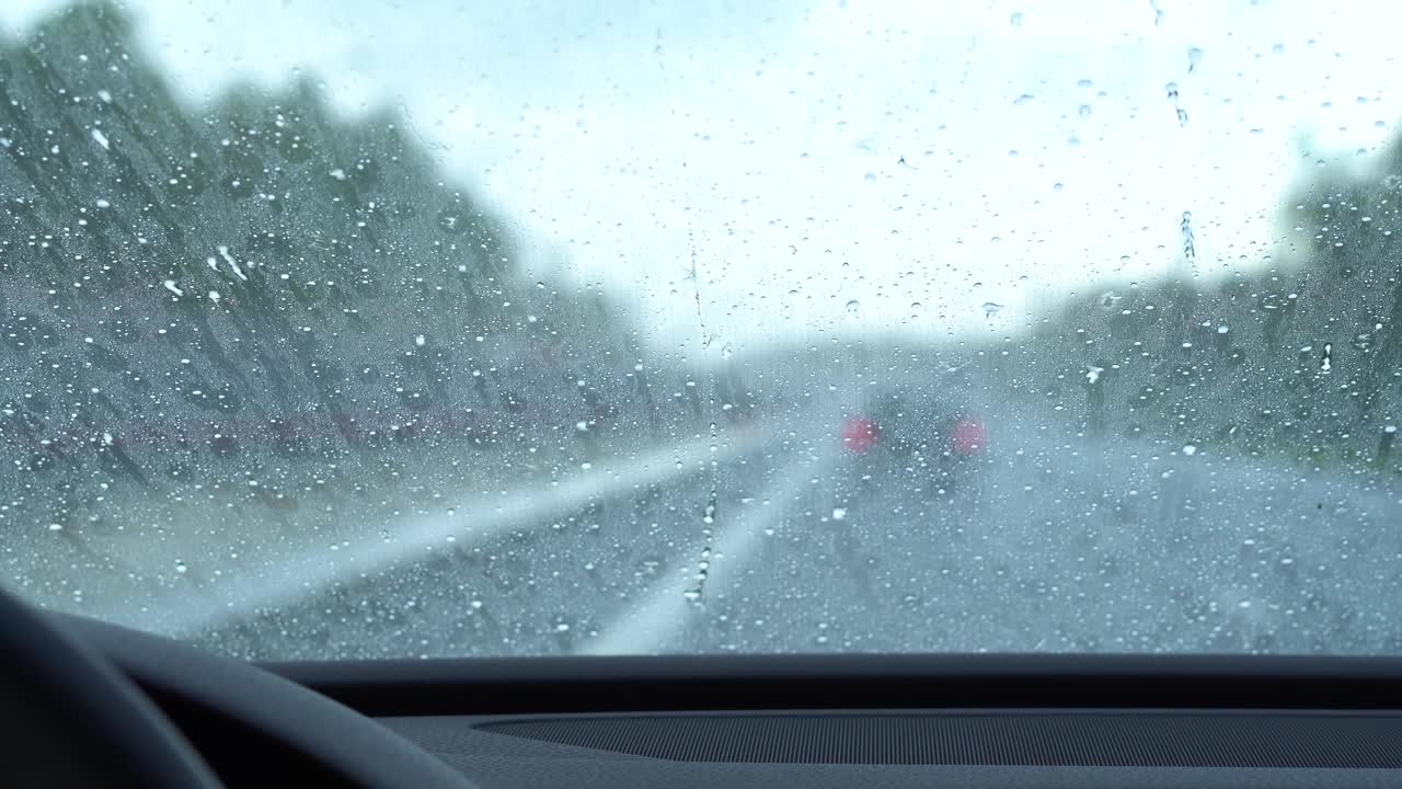 由于涂了一层防雨涂层，雨滴飞溅到挡风玻璃上。汽车抛光。视频素材