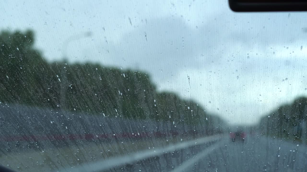 由于涂了一层防雨涂层，雨滴飞溅到挡风玻璃上。汽车抛光。视频素材