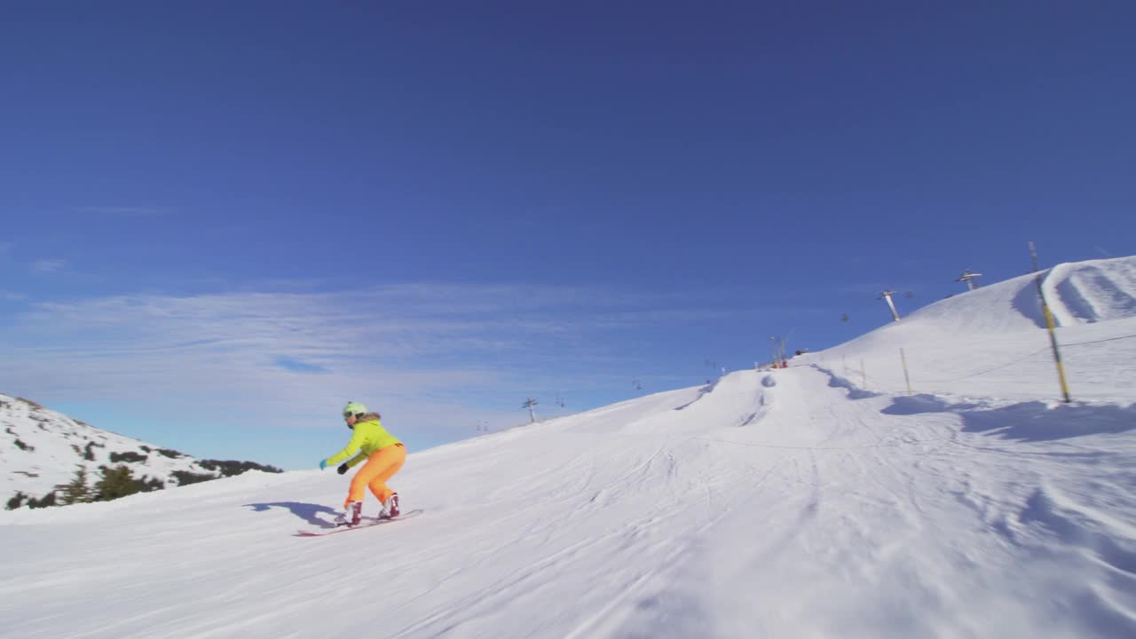 女孩在瑞士阿尔卑斯山的斜坡上滑雪，阳光和耀斑在背景中可见视频素材