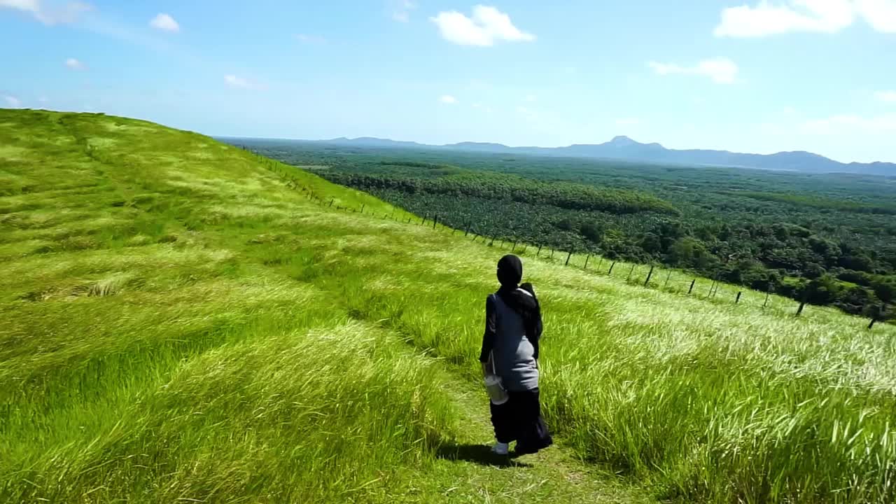 年轻女子在山顶上行走，自由，放松视频素材