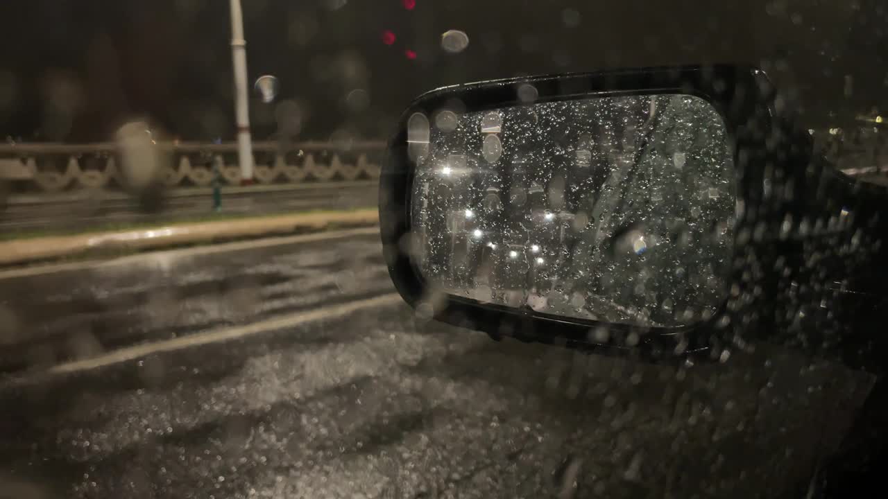 当一场大雨开始在人行道附近下时，从车里看到的景象。有选择性的重点视频下载