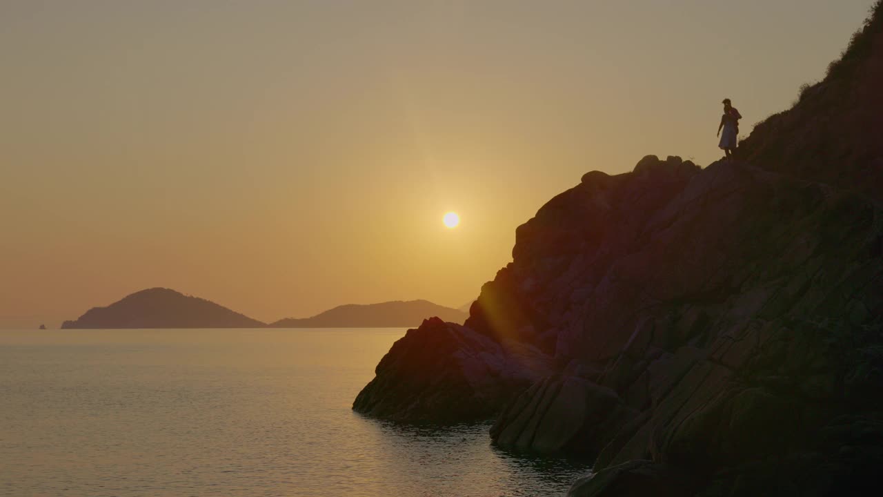 一个女人在日落时沿着海岸冥想，厄尔巴岛。视频素材