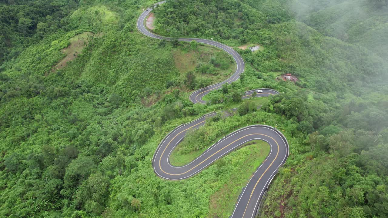 在亚洲乡村的热带森林的山地公路的鸟瞰图由无人机视频素材