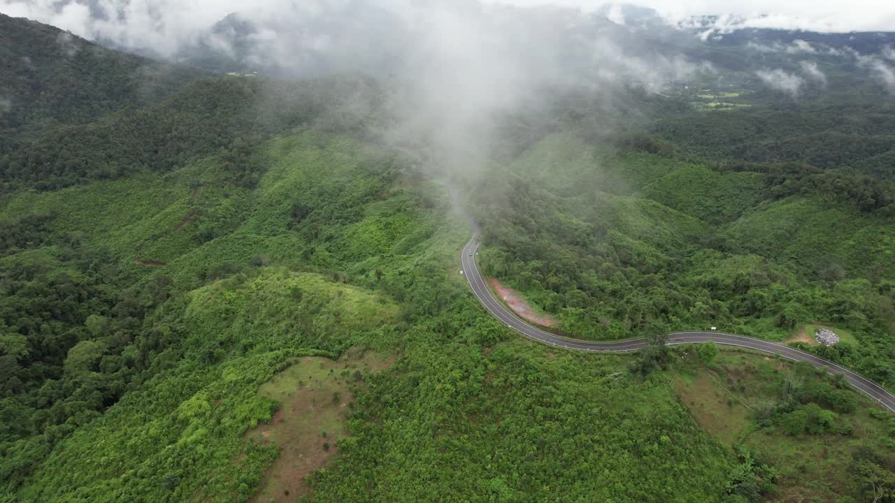 在亚洲乡村的热带森林的山地公路的鸟瞰图由无人机视频素材