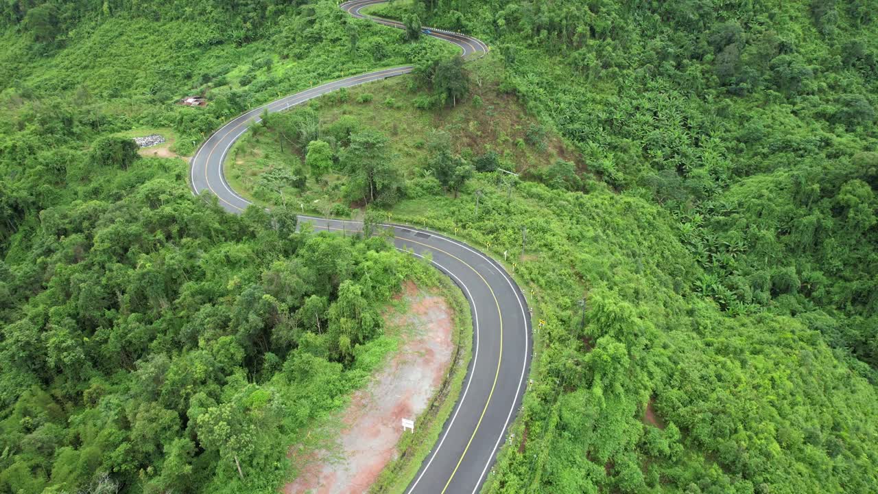 在亚洲乡村的热带森林的山地公路的鸟瞰图由无人机视频素材