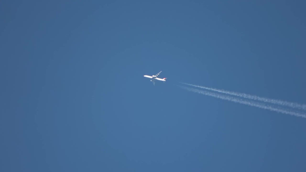 喷气式客机在高空飞行，在湛蓝的天空中留下了尾迹。视频素材