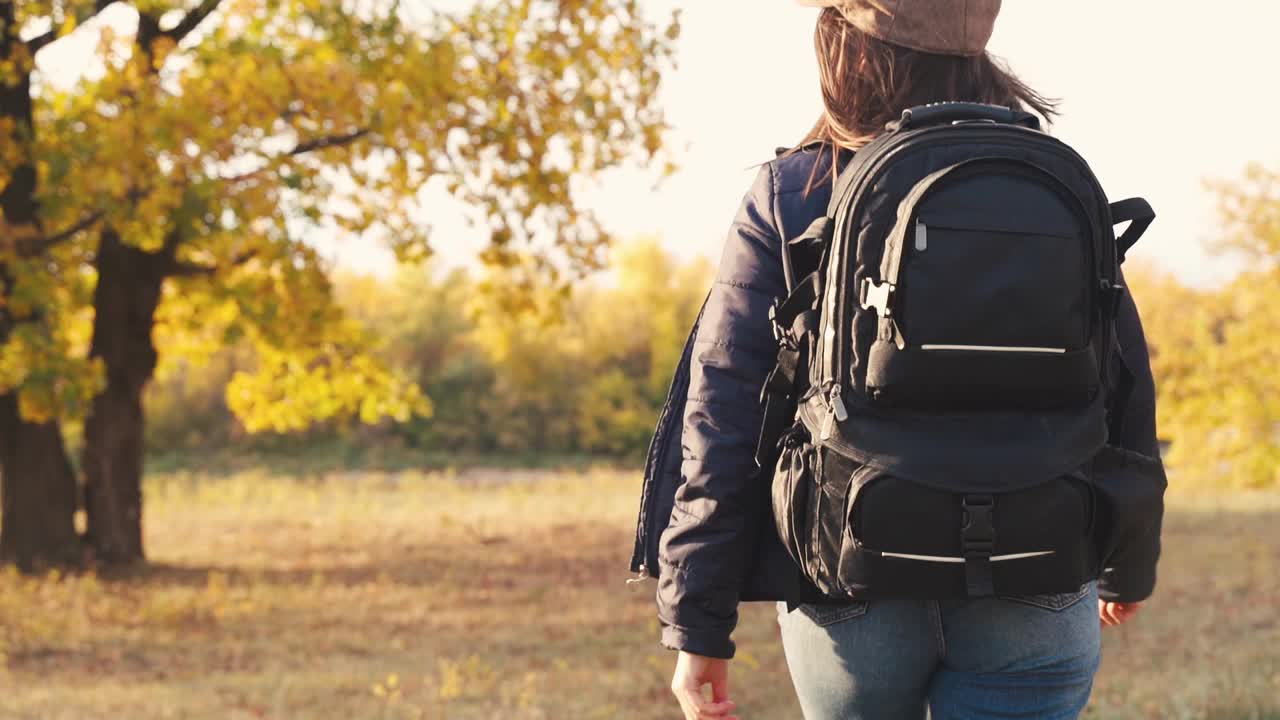 女孩游客在秋天的森林里徒步旅行视频素材