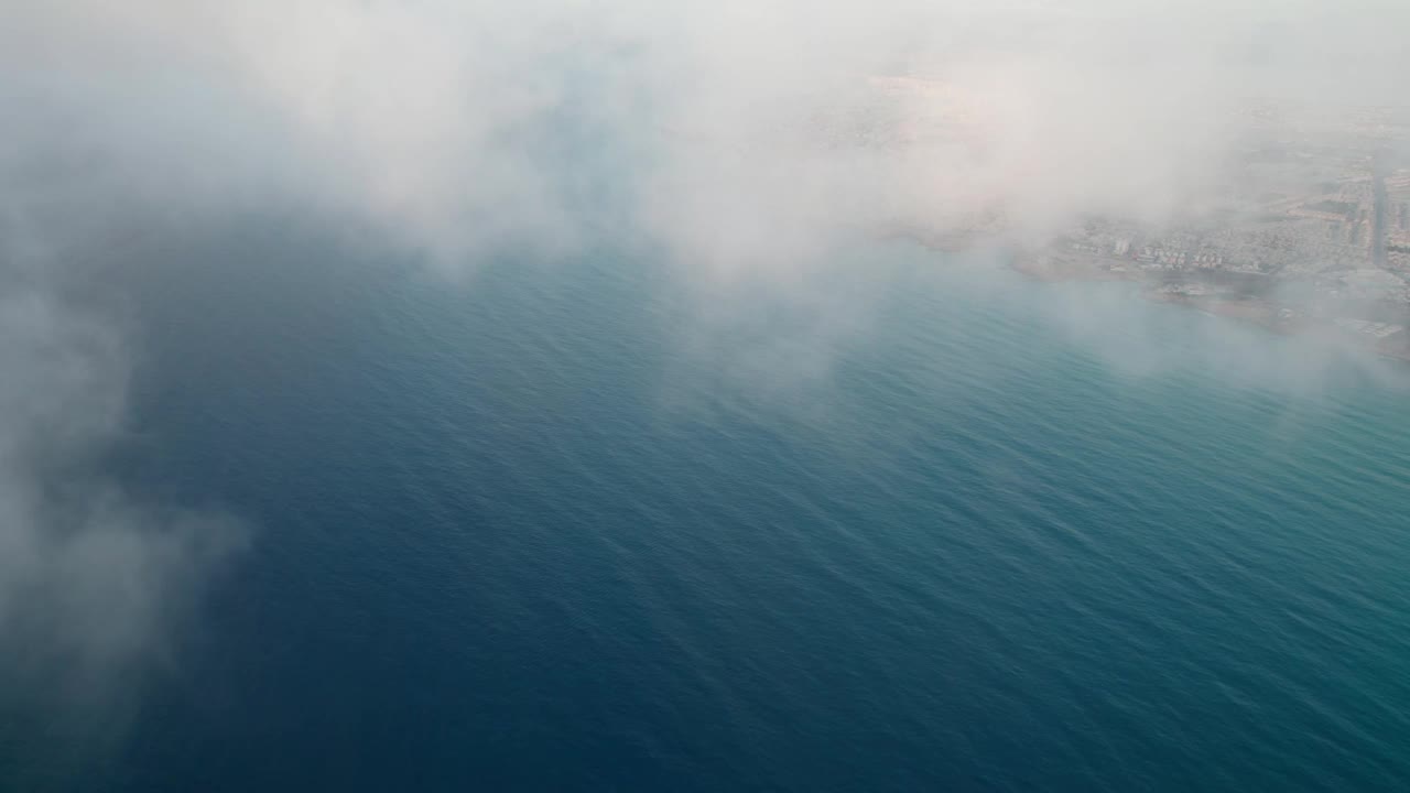 从坐飞机的角度来看。蔚蓝的海水与海滨城市形成美丽的对比。视频素材