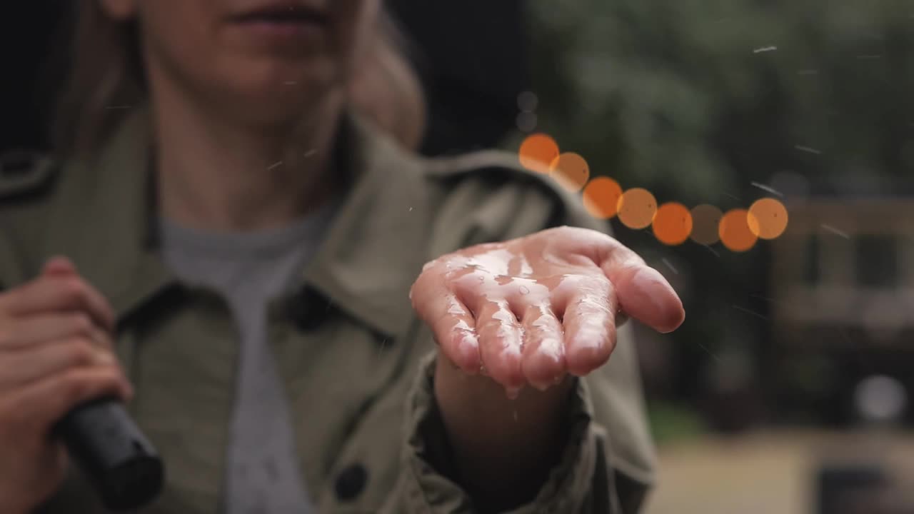 雨水落在一个打着伞的女人的手掌上视频素材