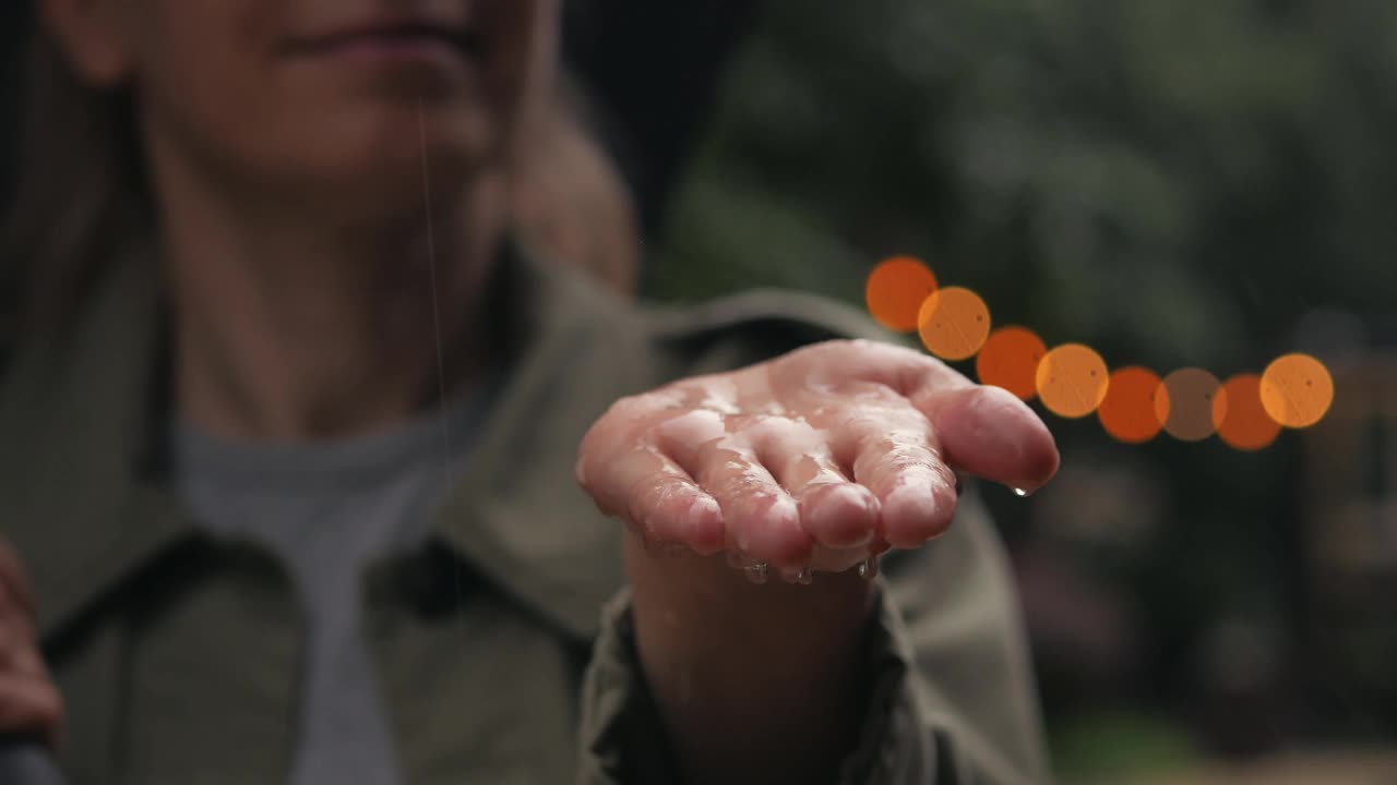 雨水落在一个打着伞的女人的手掌上视频素材