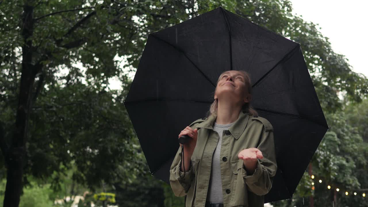 雨水落在一个打着伞的女人的手掌上视频素材