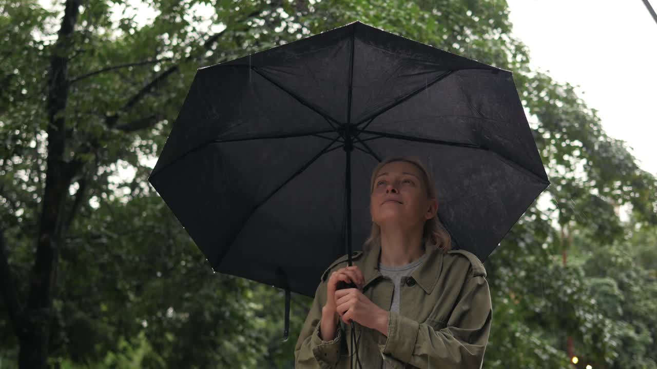 雨水落在一个打着伞的女人的手掌上视频素材