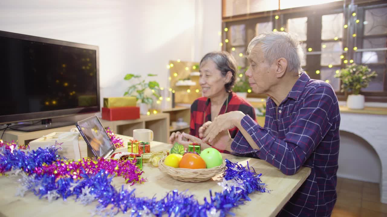 亚洲老年夫妇使用笔记本电脑与家人视频通话，一起享受圣诞节和新年假期视频素材