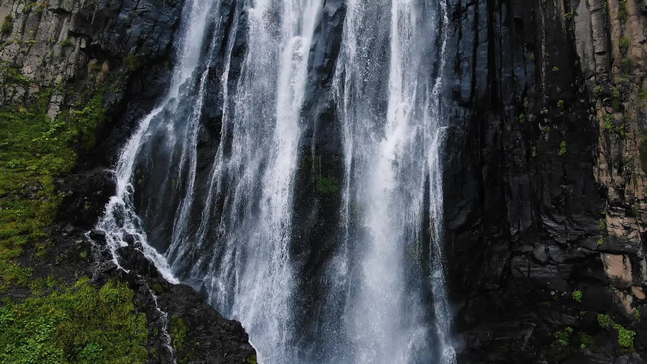 高山瀑布在黑色陡峭的岩石悬崖上视频素材