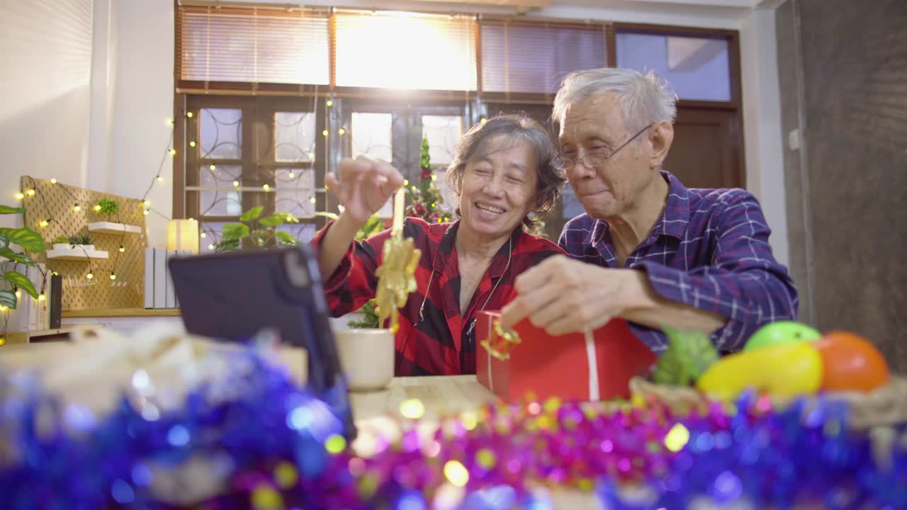 亚洲老年夫妇使用笔记本电脑与家人视频通话，一起享受圣诞节和新年假期视频素材