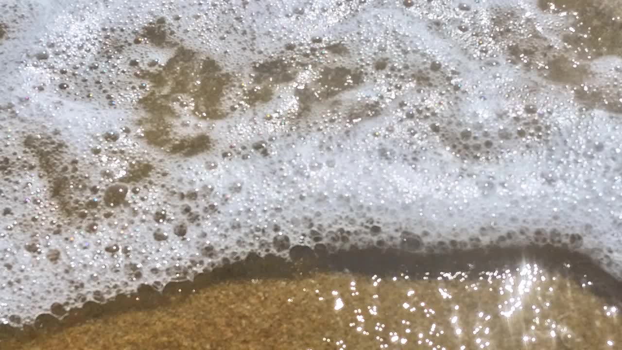 海浪卷上白色沙滩的特写镜头视频素材