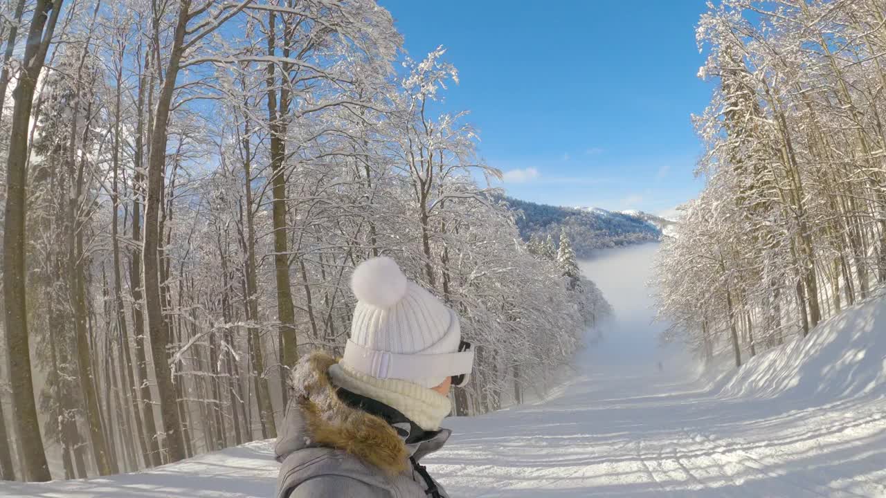 自拍:一名年轻女子在滑雪胜地的雪道上滑雪。视频素材