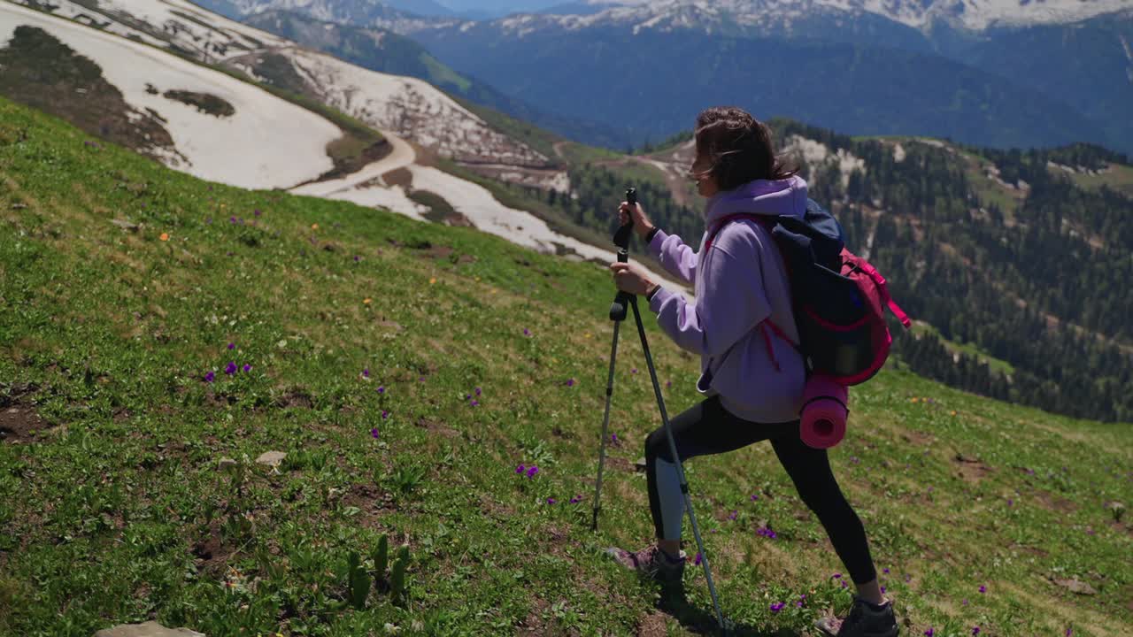 女攀登者正在登山，爬上斜坡，用登山杆帮助自己视频素材