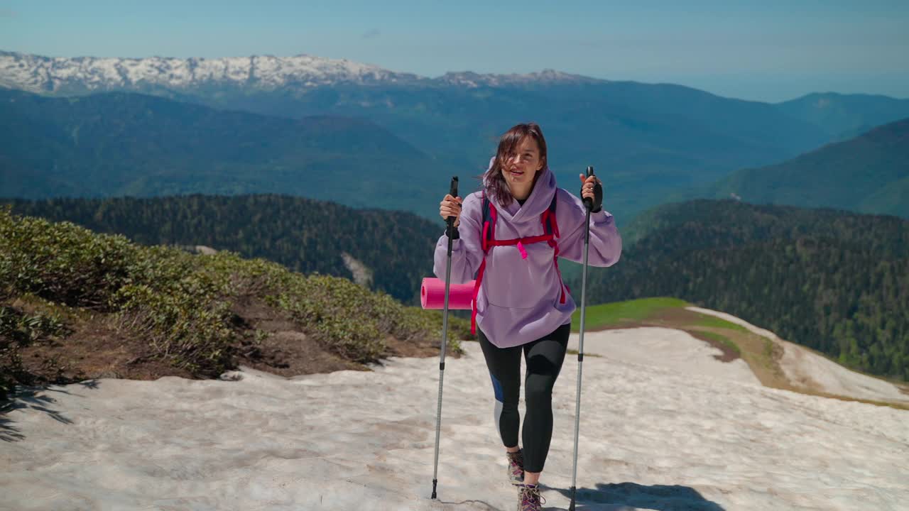 女游客在山顶，背着背包和登山杖视频素材