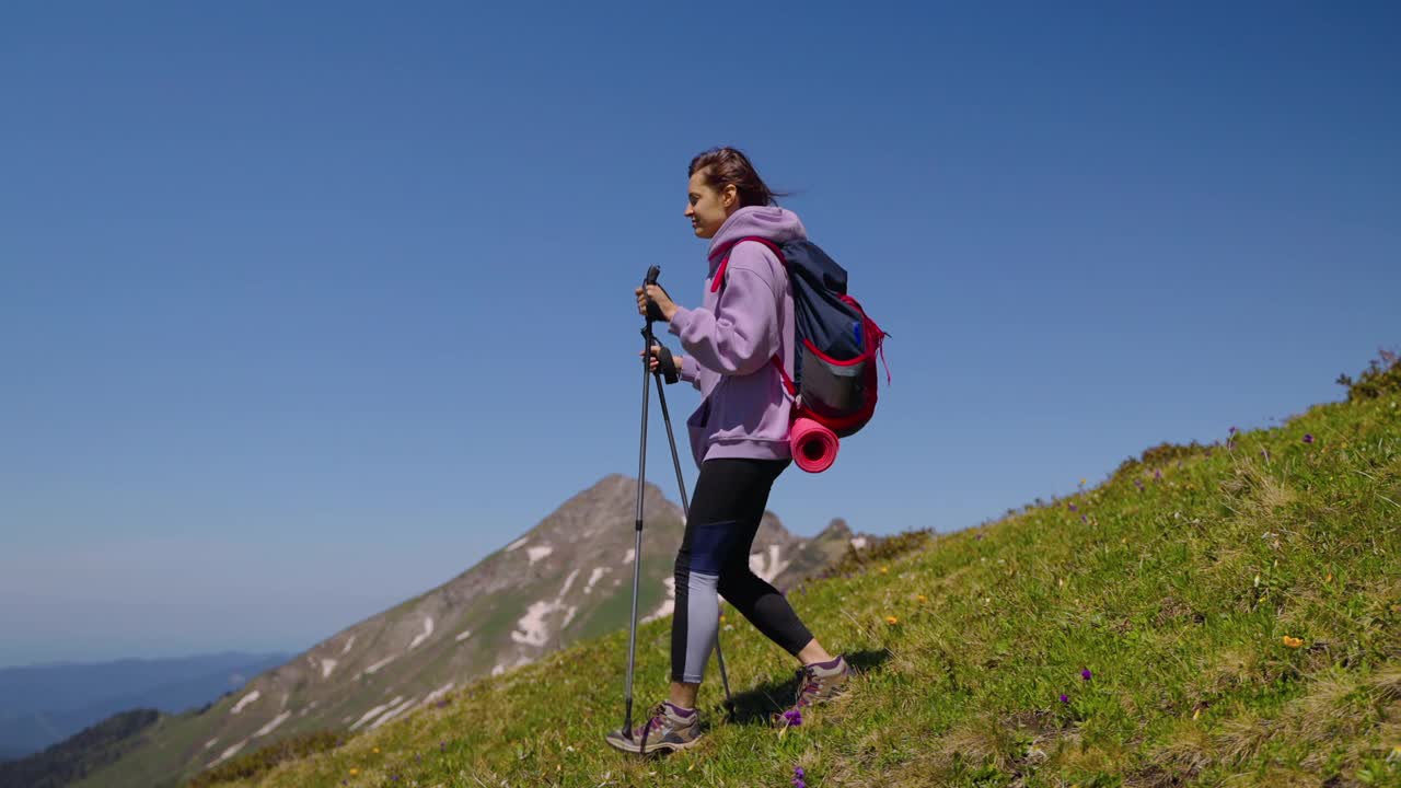 一名女子正在练习登山，她自己用拐杖帮助自己视频素材