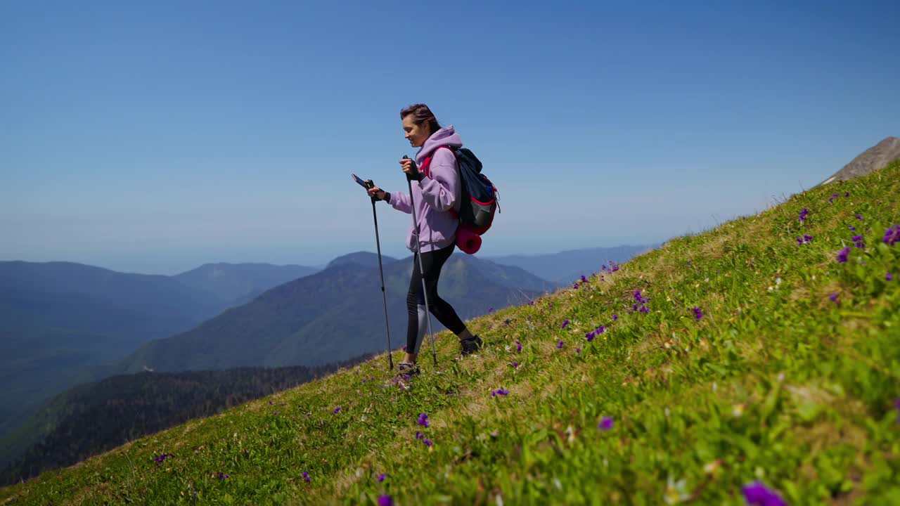 女孩背包客要用手机拍山景视频素材