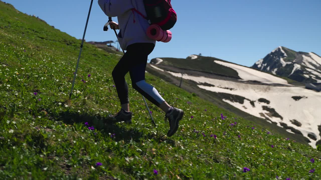 背着登山杖和背包的女人正在爬上山坡视频素材